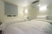 ベッドが2台置いてあり、壁にエアコンがある。