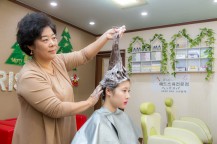たくさんの泡でかみをまとめてマッサージしている女性と、マッサージされている女性。