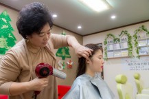 朴先生が女性の髪を乾かしている。