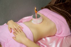 へその上に火のついた棒を立てている。