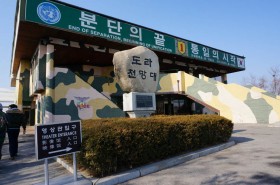 迷彩色の建物の前に大きな石が置いてある